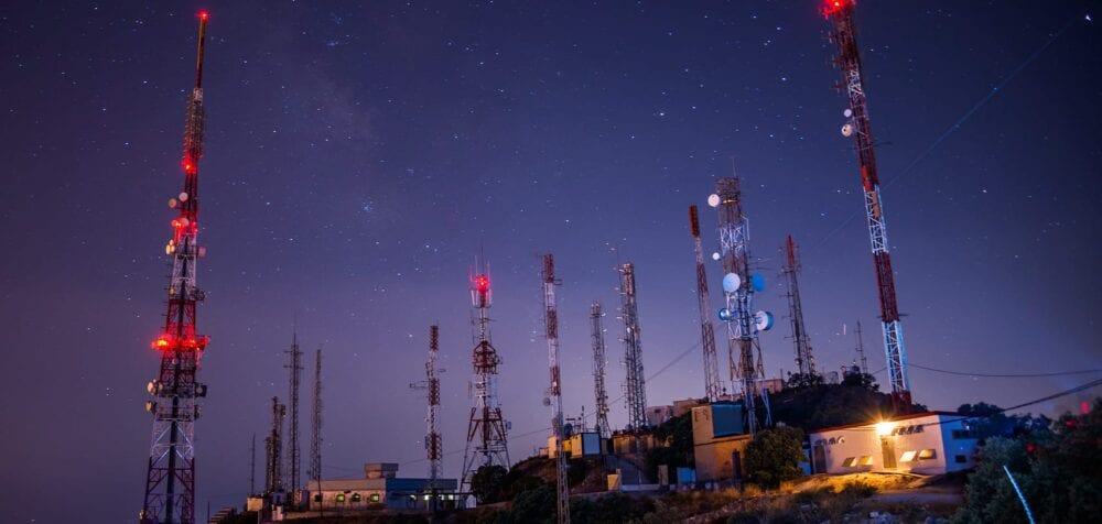 Cell towers with satellite dishes - starry sky backdrop