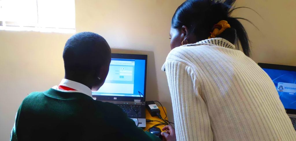 School teacher with School child at computer