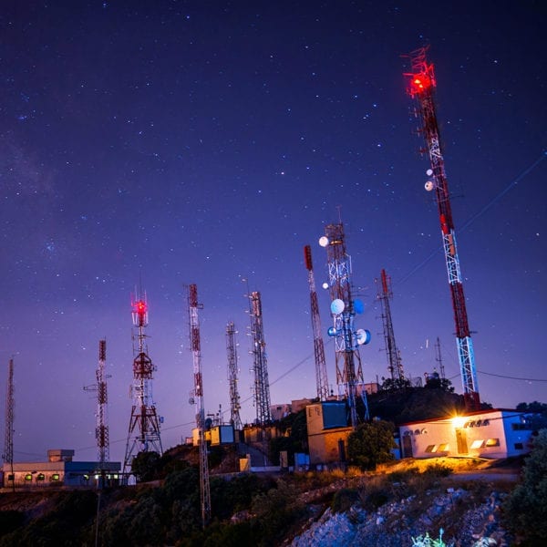 Cell towers with satellite dishes - night sky